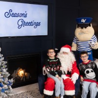 Brothers in black sweaters pose with Santa and Louie